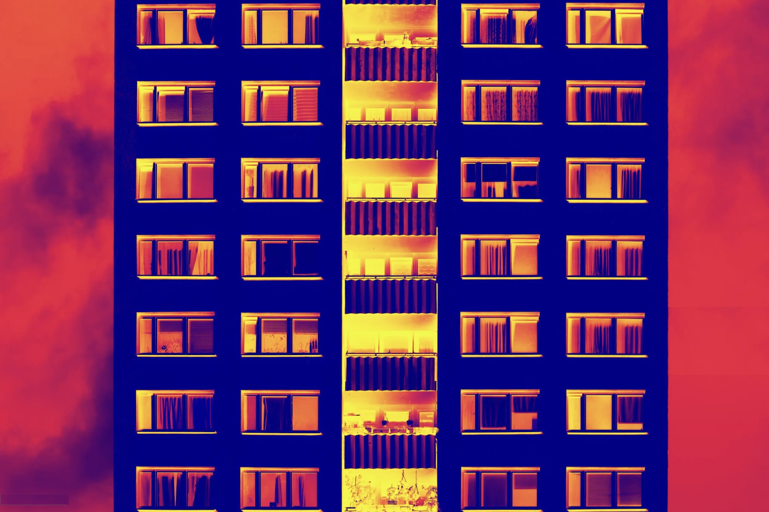Thermal infrared image of building facade at night showing heat signatures through windows and walls